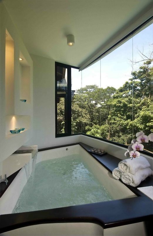 Bathroom with square bath, waterfall and beautiful view