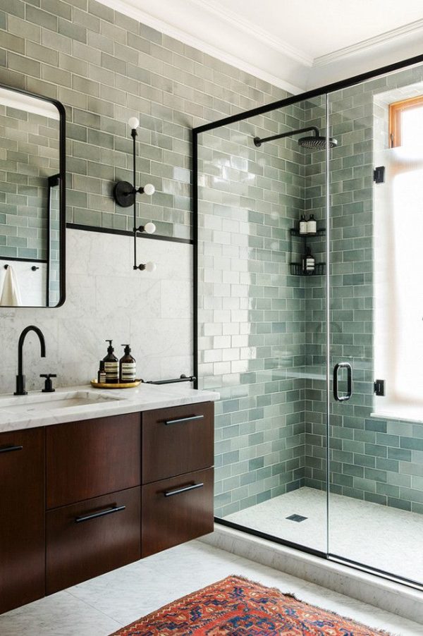 Bathroom with stone tile backsplash and green glass subway tiles on walls