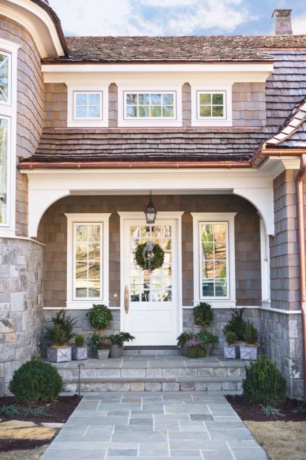 Cape Cod style house with white front door ,wreath and potted plants