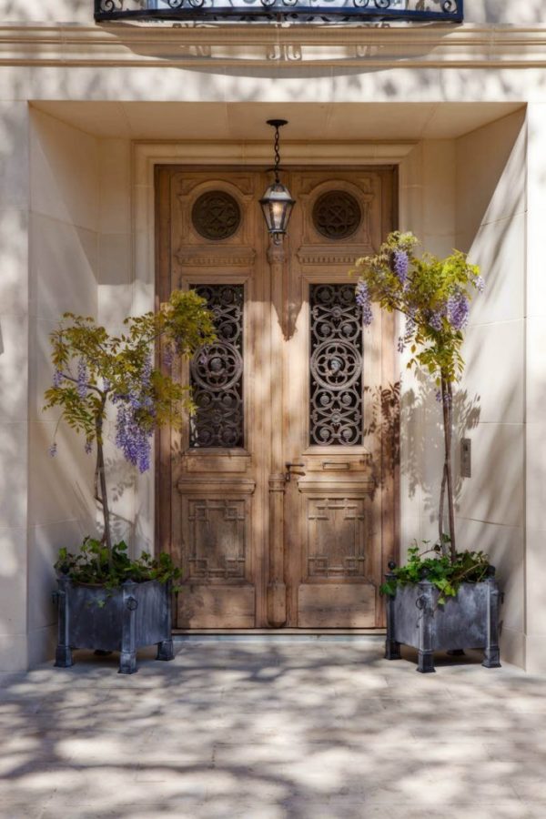Carved wood Front door with Potted Wisteria plants