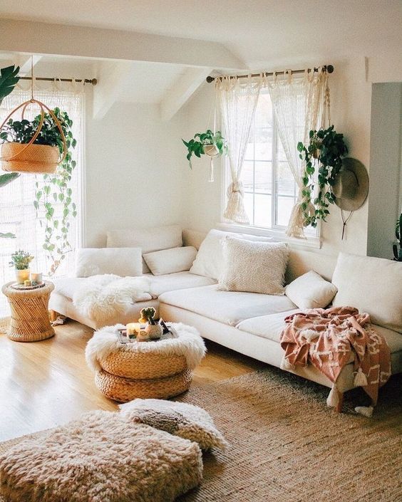Cream colored living room with brown rattan rug, plants, cream couch
