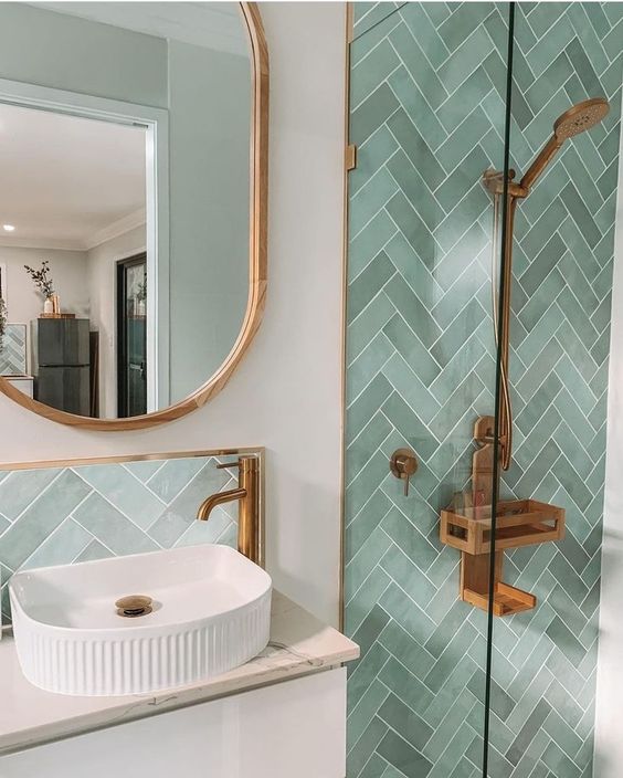 Modern-bathroom-with-herringbone-green-tile-backsplash-with-a-custom-gold-trim