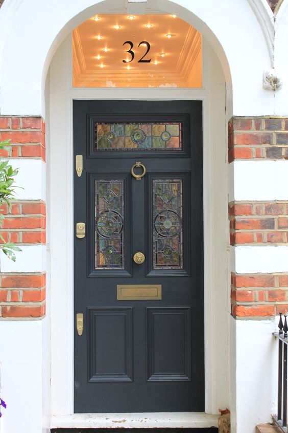 Black Front Door With Brass Accents And Mosaic Glass Panels