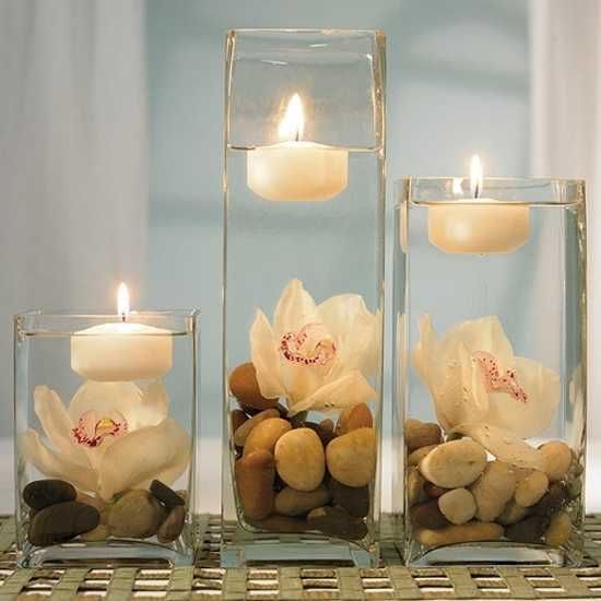 Decorative vases with pebbles flowers and candles