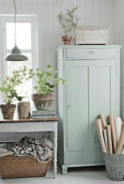 Shabby chic room with vintage furniture, pendant light and potted plants