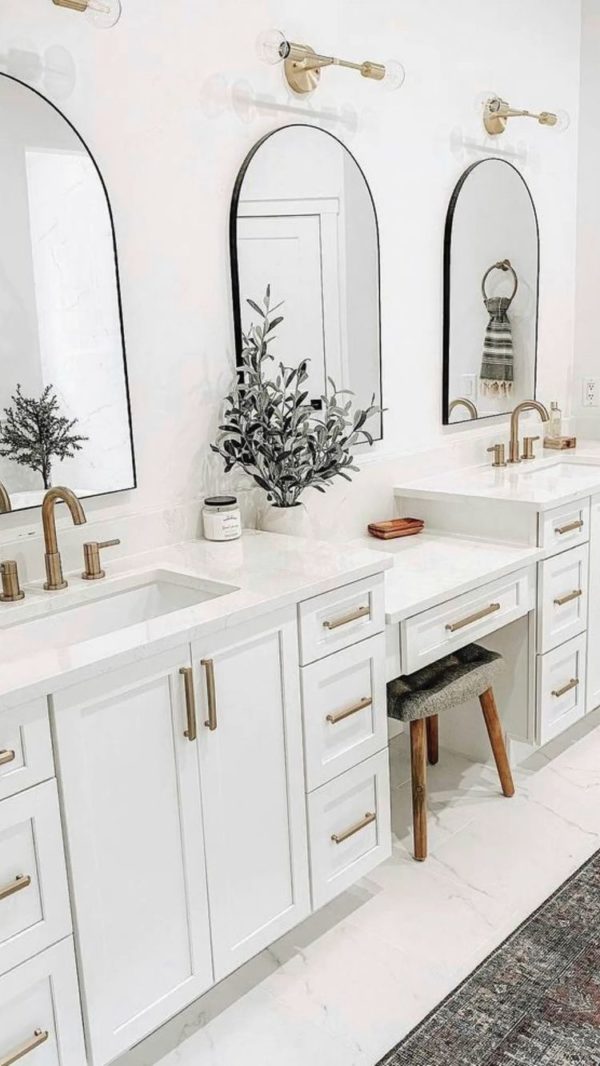 all white big master bathroom with double vanity , mirrors and gold accents